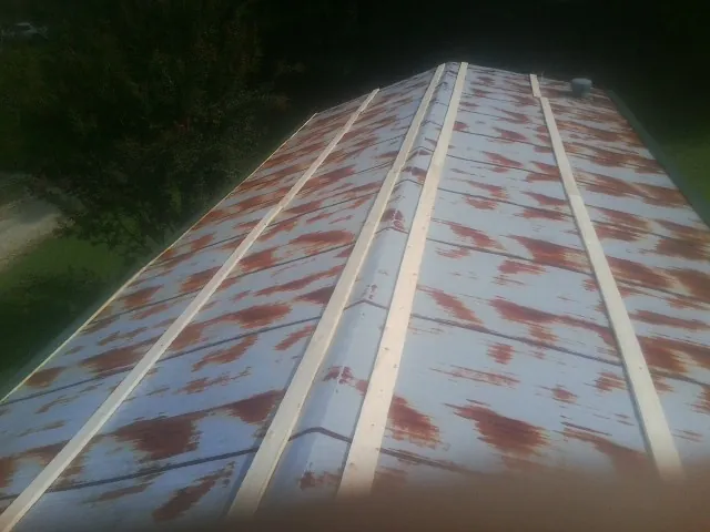 Rusted metal roof panels with new wood purlins before replacement — Storm Damage Roof Repair in Bybee by Roofing Brothers