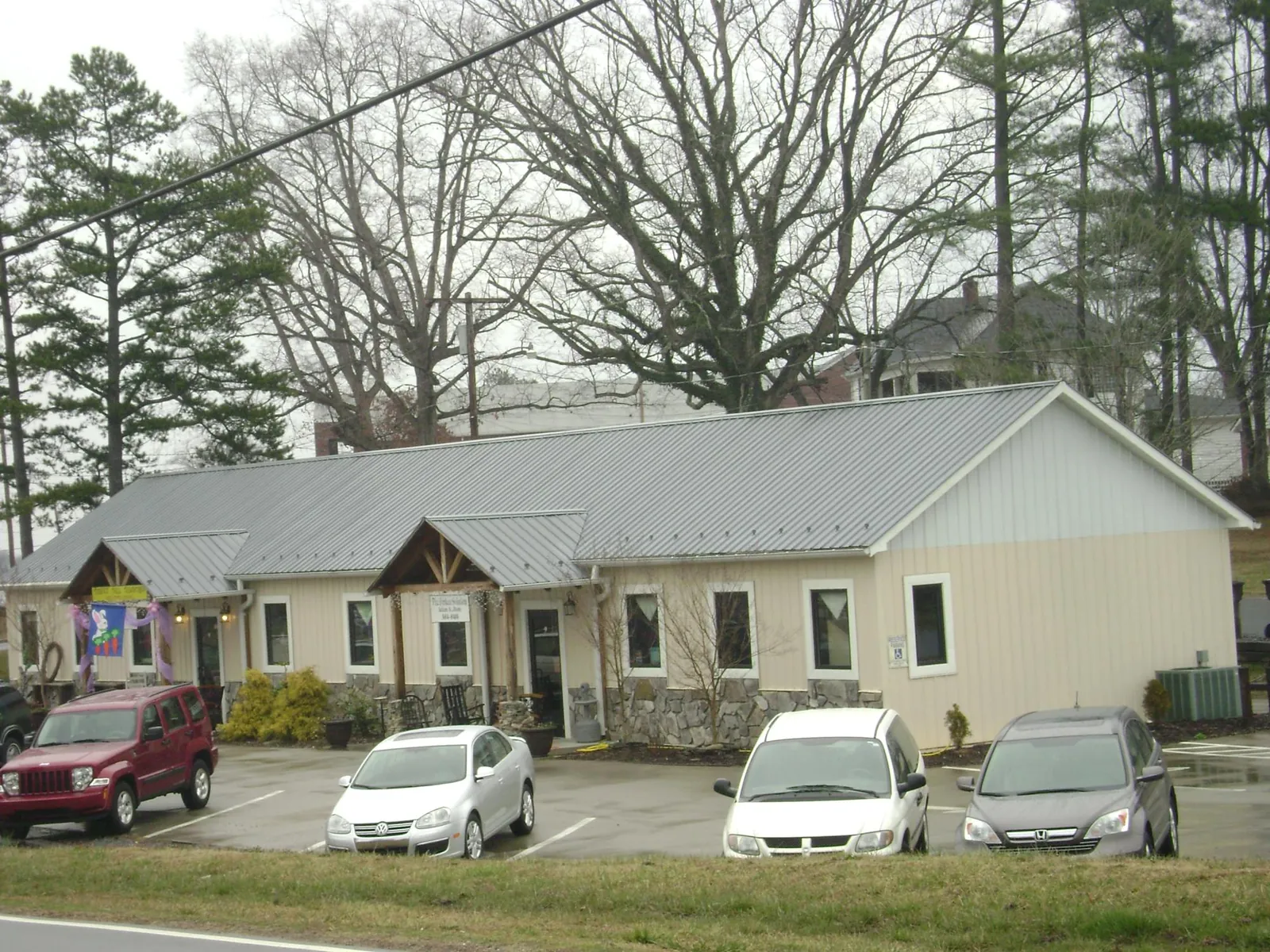 Gray metal roof with timber entry brackets on a small commercial building in Bybee