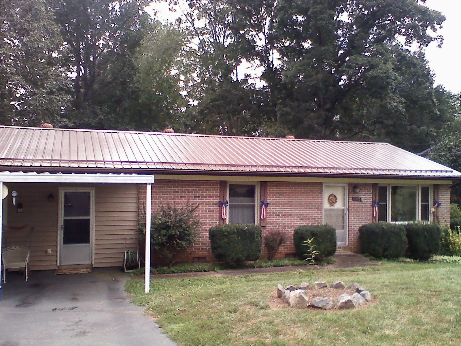 Bronze metal roof and carport on a brick ranch home — Roof Repair work by our crew in Bybee